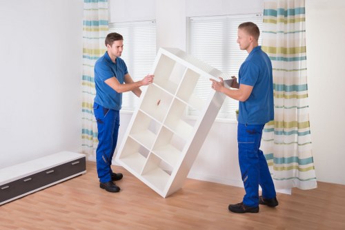 Local movers carrying furniture through a Shepherds Bush property